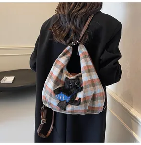 Detail der Wollkaro-Tasche mit 3D-schwarzem Katzen-Aufnäher und verstellbarem Lederriemen