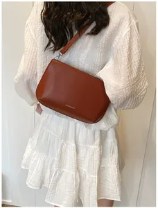 Sac bandoulière en cuir marron avec logo LUKADI BAG montré sous un angle latéral élégant