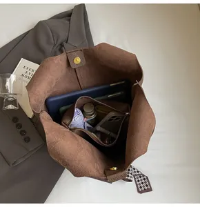 Interior view of brown tote bag showing multi-layered compartments and large capacity
