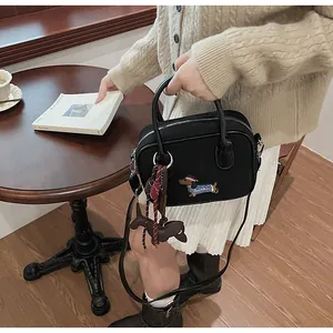 Detail of black canvas Boston bag with dachshund embroidery and cute dog pendant