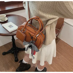 Brown vintage leather handbag with small side pouch and checkered bow charm detail