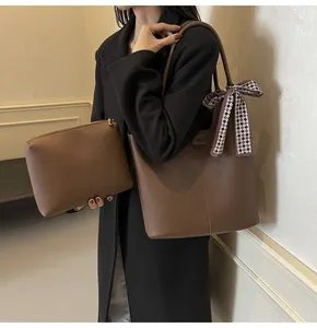 Brown leather tote bag with matching pouch and stylish checkered scarf decoration