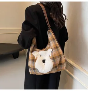 Detail der karierten Hobo-Tasche mit Plüschwelpen-Stickerei und Leder-Schultergurt