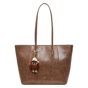 Sac cabas classique en cuir marron caramel avec un joli porte-clés peluche et bretelles