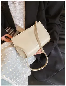 Détail du sac bandoulière minimaliste blanc crème avec finitions argentées et similicuir lisse