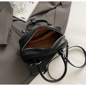 Top view of black minimalist crossbody bag with brown lining and mini coin purse detail
