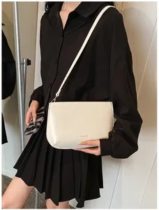 Détail du sac à bandoulière minimaliste beige avec logo Lukadi Bag sur le devant