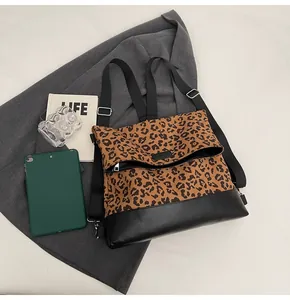 Detail of leopard print backpack with black leather base and silver metal buckle
