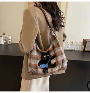 Detail der Tweed-Einkaufstasche mit kariertem Muster, schwarzem Katzen-Patch und Lederband