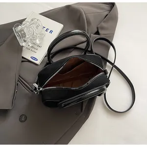 Detailed interior of black canvas handbag showing brown lining and silver zipper hardware