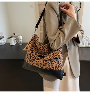 Detail of vintage leopard print tote bag with black leather base and wide shoulder strap