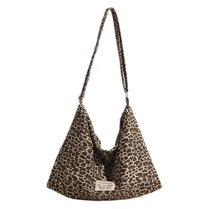 Large leopard print canvas hobo bag with adjustable strap and decorative label