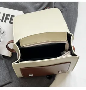 Detailed interior of contrast color handbag with zipper pocket and silver hardware