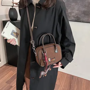 Brown matte suede handbag with dachshund dog patch and chocolate pendant