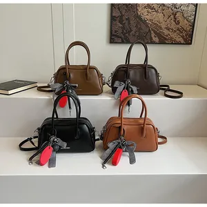 Detail view of four minimalist leather bowling bags in black, coffee, caramel and tan colors