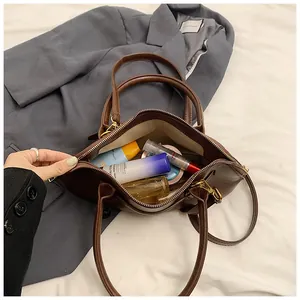 Spacious interior of retro brown leather shell bag showing cosmetics storage capacity