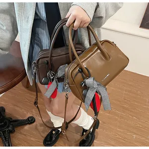 Detail of leather bowling bags with plaid bows and charms for a stylish retro look