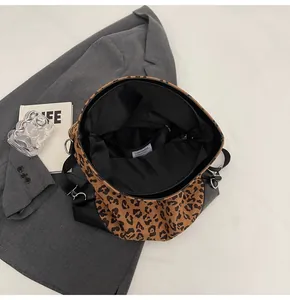 Internal view of leopard print tote bag showing black lining, zipper pocket and strap
