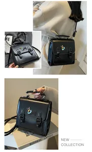 Detail of black faux leather backpack with colorful dog embroidery and buckle closure