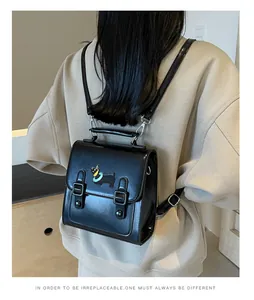 Detailed back view of a black retro PU leather backpack with a colorful dog patch detail