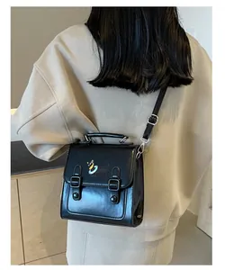 Detail of black faux leather mini satchel with cute dog embroidery and adjustable strap