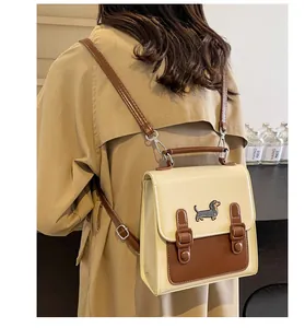 Detail of mini backpack with dachshund embroidery and adjustable straps worn by model