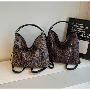 Detalle de mochilas con estampado de leopardo con cremalleras dobles y lazos de cuero negro