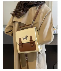 Detail of a retro cream and brown crossbody bag with dachshund embroidery and dual straps