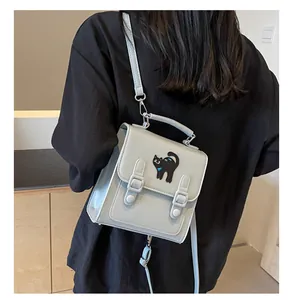 Detail view of light blue mini backpack with black cat embroidery and adjustable straps