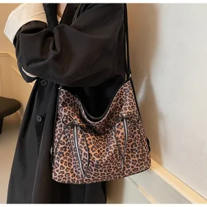 Detalle de bolso grande con estampado de leopardo, lazo y cremalleras verticales
