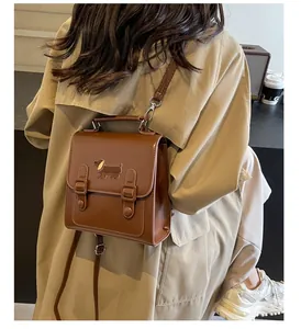 Detailed back view of a brown leather mini backpack with dachshund embroidery on a model
