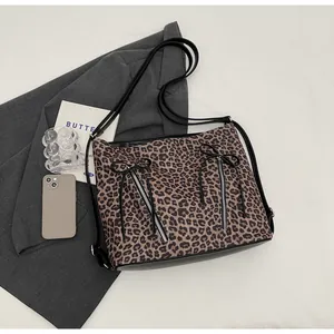 Primer plano de bolso de hombro con estampado de leopardo, lazos y cremalleras dobles