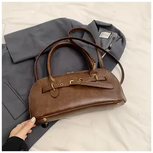 Detail of vintage brown shell bag with gold hardware and protective metal bottom studs