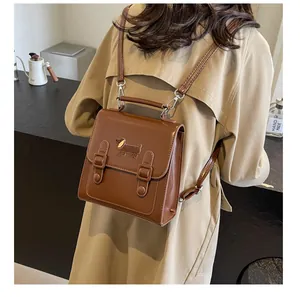 Detail of vintage brown leather backpack with dachshund embroidery and buckled straps