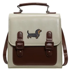 Two-tone retro crossbody backpack in cream and brown with dachshund embroidery