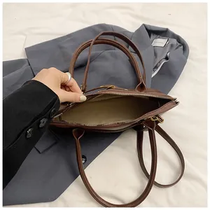 Detail shot of the brown matte leather tote showing zip closure and spacious interior
