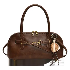 Retro dark brown shell-shaped shoulder bag with decorative belt and baseball charm