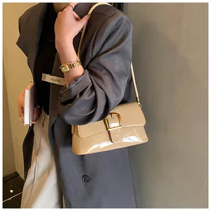Detail of khaki patent leather shoulder bag with a gold buckle and adjustable strap