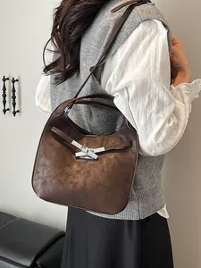 Retro dark brown leather bucket bag with geometric silver buckle shown on model