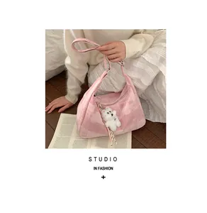 Détail du sac à main rose avec texture en tissu et adorable pendentif petit chien