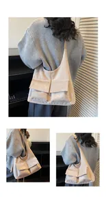 Detail of a beige suede crescent shoulder bag showing dual front flap pockets and wide strap