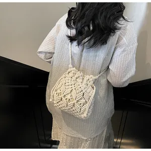 Close-up of white macramé woven bucket bag with intricate geometric knot patterns