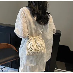 Detail of bohemian woven straw bucket bag showing intricate texture and drawstring