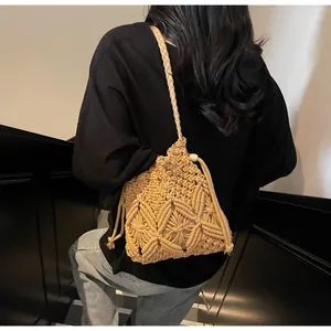 Detailed texture of handmade woven straw bucket bag with drawstring and tassel details