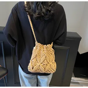 Detail of hand-woven bucket bag with hollow diamond pattern and braided shoulder strap