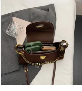 Detail view of brown leather bag interior showing capacity for two phones and gold hardware