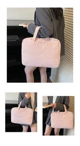 Détail d'une sacoche d'ordinateur rose matelassée avec tissu doux et poignées hautes