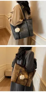 Detail of dark grey and brown tote bags with marble texture and plush charm