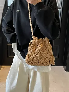 Handcrafted woven straw bucket bag with macrame pattern and drawstring shoulder strap