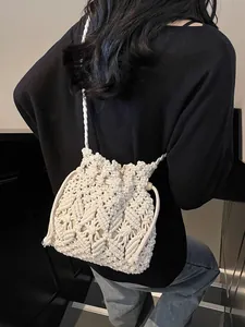 Minimalist ivory woven straw bucket bag with drawstring and cotton rope shoulder strap